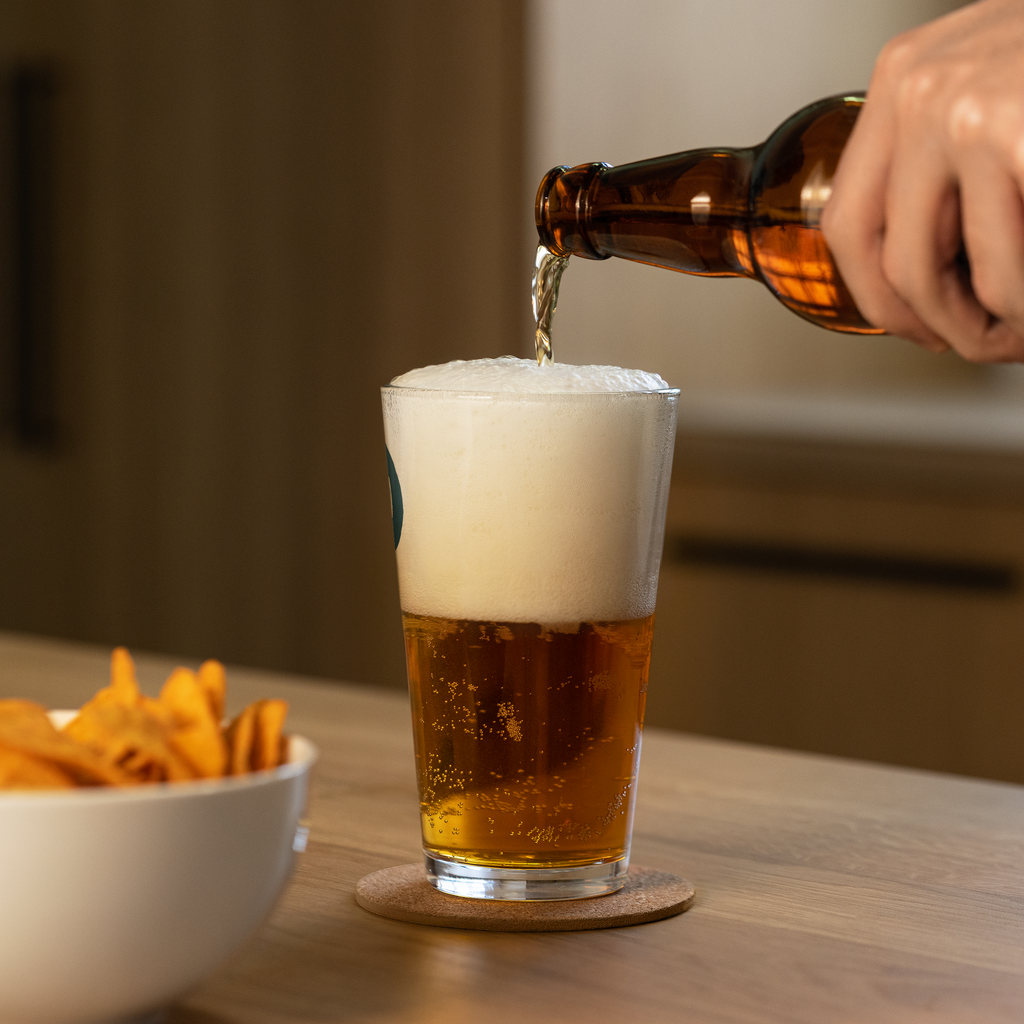 Beer being poured into a Dads in the Game Signature pint glass, side view