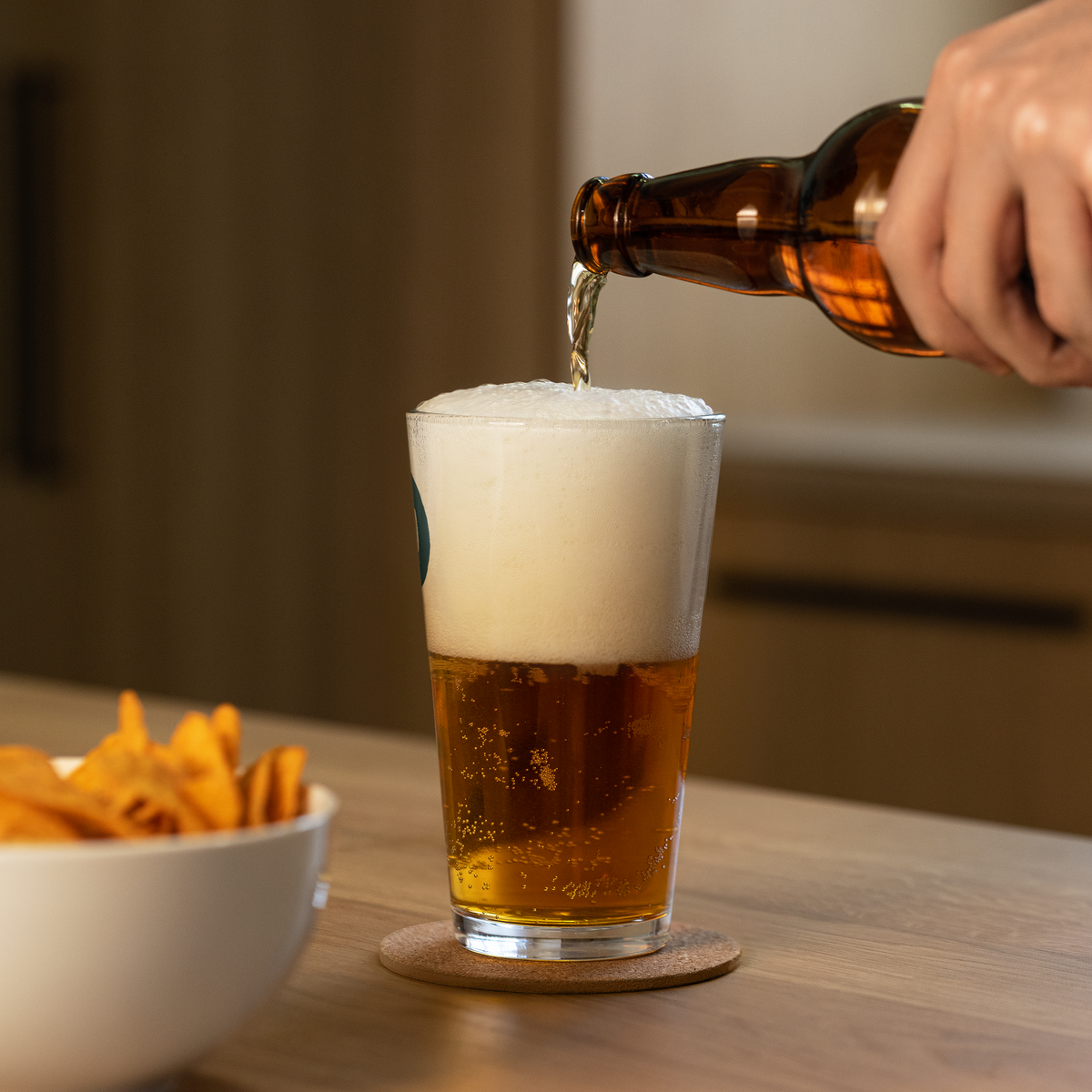 Beer being poured into a Dads in the Game Signature pint glass, side view